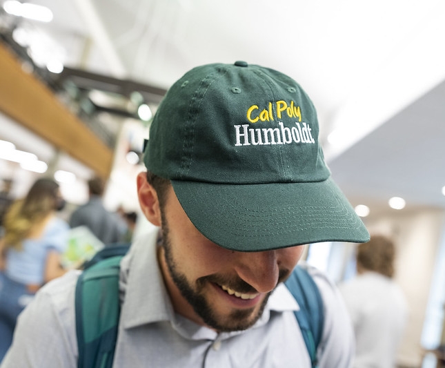 man wearing hat reading "cal poly humboldt"