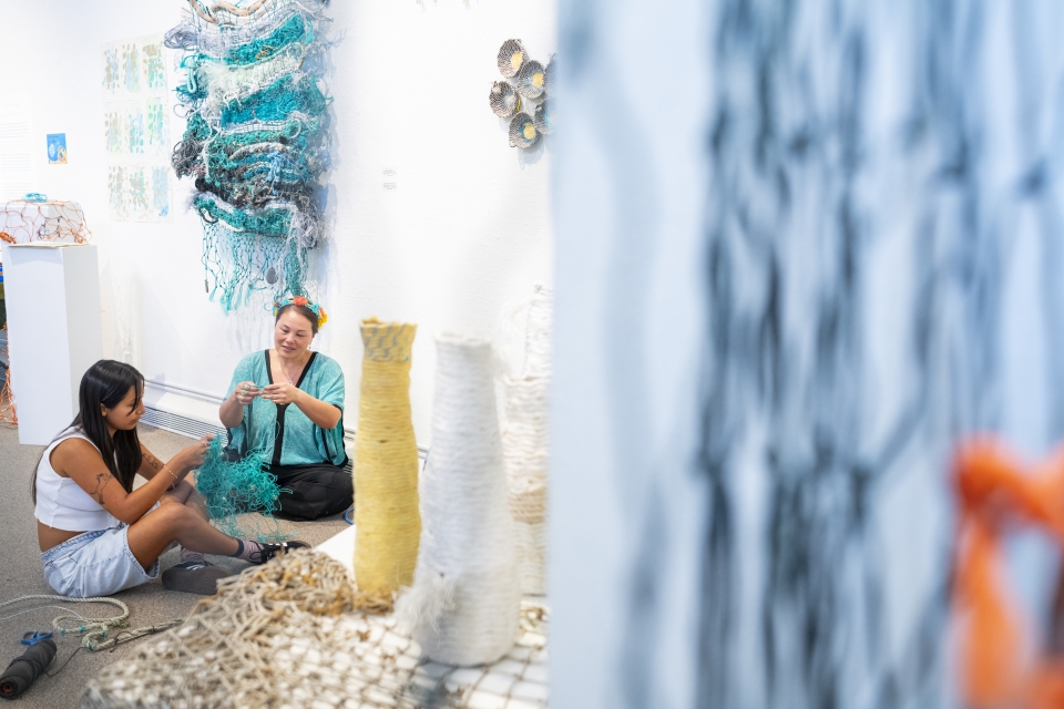 A woman creating wolven tapestry art in an art gallery